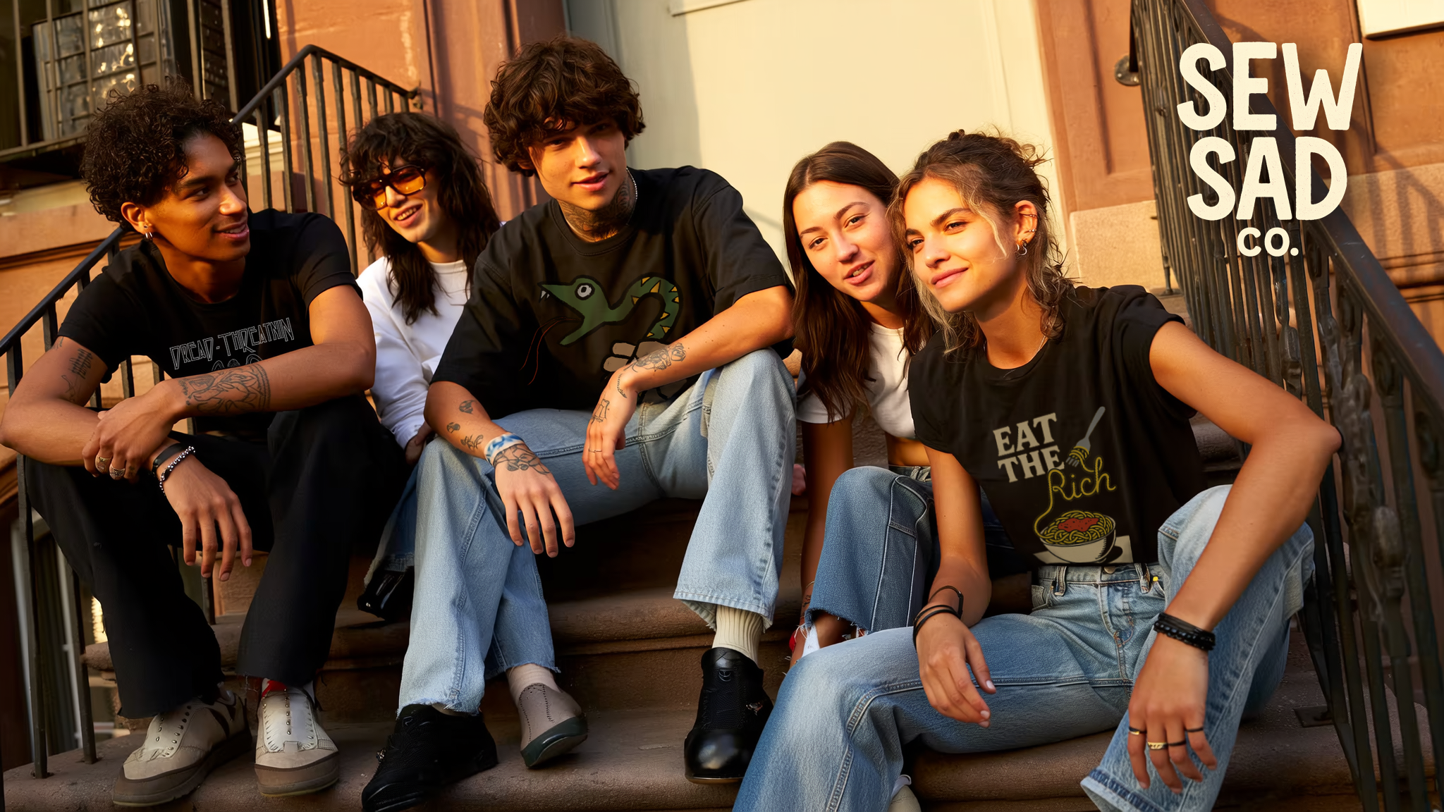 Five young people sitting on a stoop with 'Sew Sad Co.' branding.